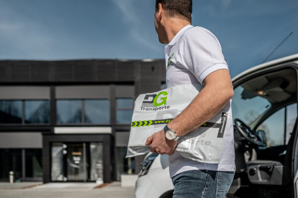 Ein Mann hält ein Paket, das Teil eines seriösen Goldankaufs ist, der durch ein Werttransportunternehmen abgewickelt wird.