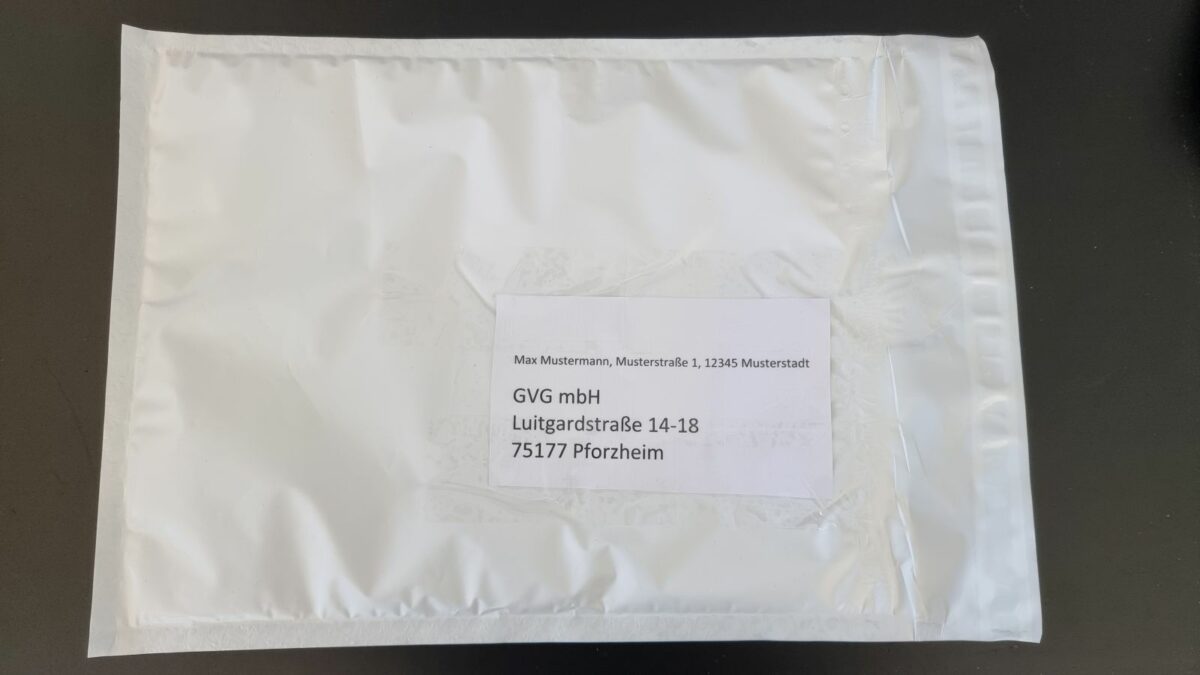 Weiße Versandtasche für Goldverkauf auf schwarzem Hintergrund